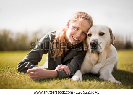 Smiling teenage girl with her Labrador dog.