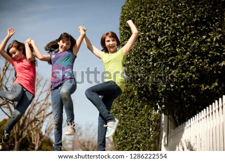 Three friends jumping in the street and having fun together.