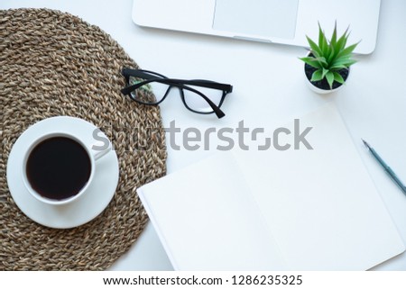 Top view working space with laptop, plant, cup of coffee , notebook, pen and glasses