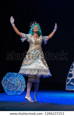 Actress in princess costume plays a performance for children on the theater stage