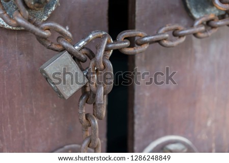 Closed lock with a chain on an old wooden door