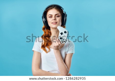 Gamer woman in headphones and with a joystick in his hand                       