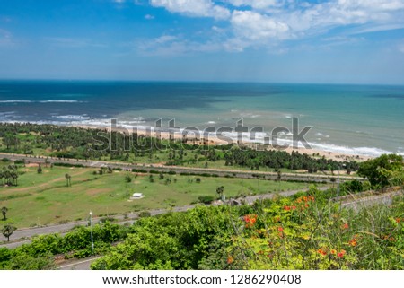 top view of sea beach road looking awesome from top of a mountain with blue sky & beautiful sea view.
