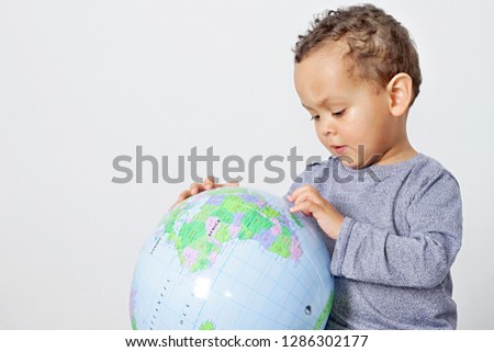 small boy holding globe on earth day smiling with white background stock photo
