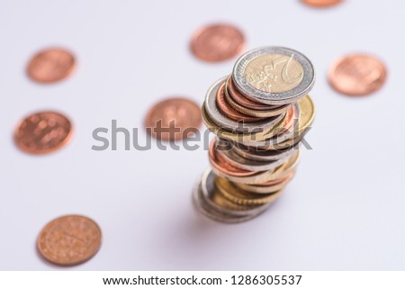 Euro coins stacked on each other in different positions on a white background