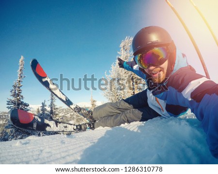 Selfie Guy sportsman goes on normal skiing on ski slope with action camera. Sunset. winter.