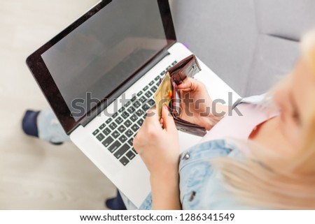 Woman is holding credit card and using laptop computer. Online shopping concept. Close up.