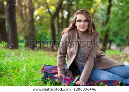 Portrait of a beautiful girl in park. Teenage girl with colorful scarf and brown coat. Close up photo. Young student have fun. Lifestyle photo. happiness concept - smiling girl.