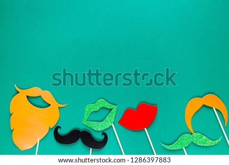 Creative st Patricks Day green background. Flat lay composition of Irish holiday celebration with photo booth decor: beard, moustache, lips. With Copy space, greeting card, top view