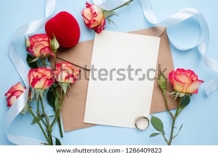 card mockup with roses, petalts, ribbon ring on blue background. tender invitation
