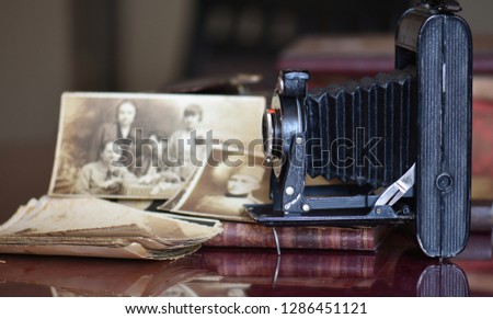 Old photos and very old camera on the table