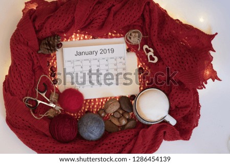 Calendar January 2019 with cup of coffee, red warm scarf and craft work decoration. Top view.