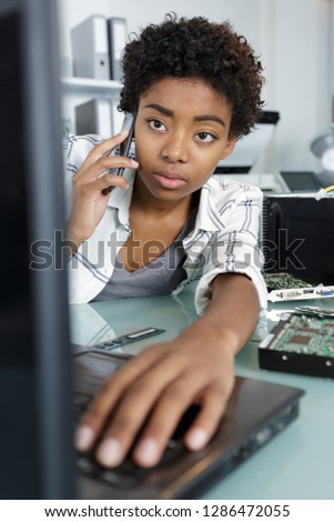 computer technician reaching forward to type on laptop