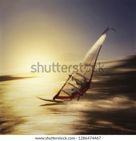 Side view of a man windsurfing.