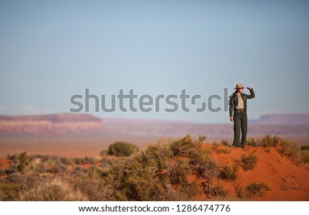 Park ranger observing a desert landscape. Royalty-Free Stock Photo #1286474776
