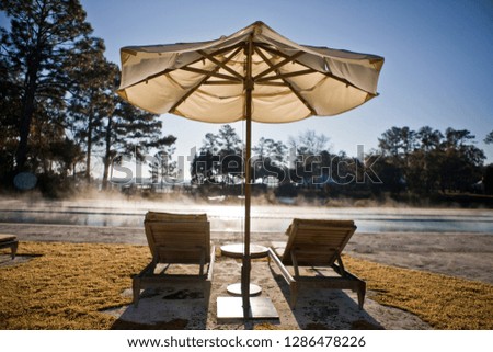 Resort swimming pool with sun umbrellas and deck chairs