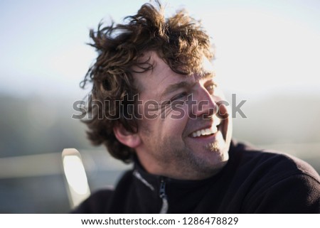 Mid-adult man sitting on a sail boat at sea.