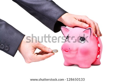 Hand gives coin to moneybox isolated on white background
