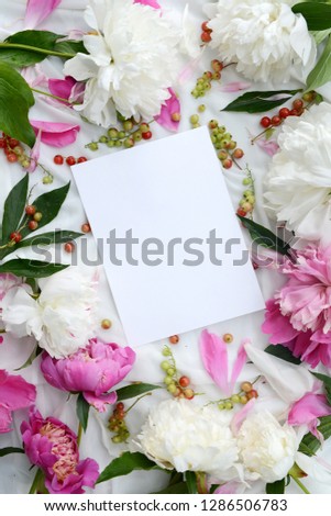 Beautiful flower composition. Mockup with a white sheet of paper and large lush peonies. Summer vintage decor.