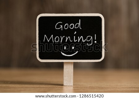Good Morning blackboard sign against wooden background.