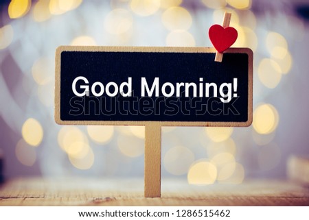 Good Morning blackboard with red heart against beautiful shiny background.
