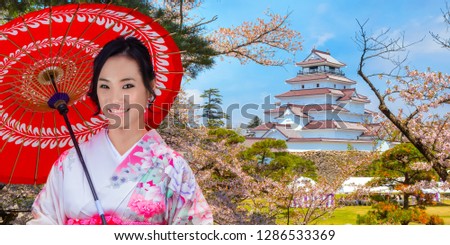 Japanese woman in Kimono dress with Aizuwakamatsu Castle and cherry blossom in Fukushima, Japan 