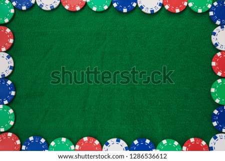Frame of Colorful gambling chips on green background with copy space.