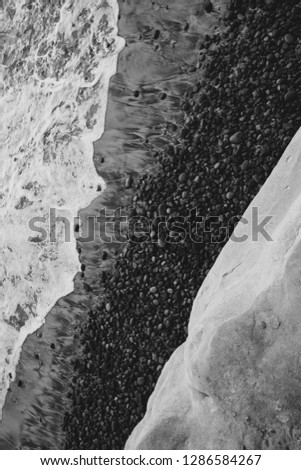 Aerial view of ocean waves crashing upon a rocky california coastline