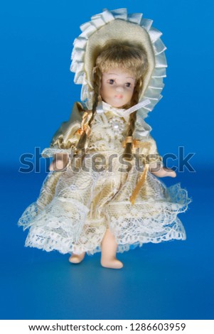 Cute vintage porcelain doll in an old-fashioned dress.