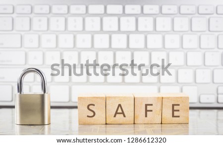 Close keypad lock with word SAFE on wooden cubes, white keyboard on background. Online safety, Information security, internet connection, system login, information privacy, database storage concepts.