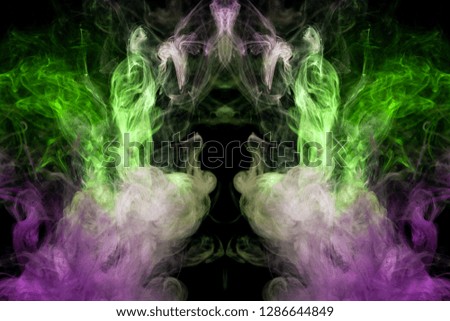 Fantasy print for clothes: t-shirts, sweatshirts.  Colorful pink and green smoke in the form of a skull, monster, dragon on a black isolated background. Background from the smoke of vape

