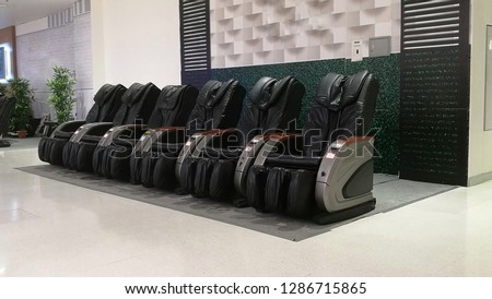 Black leather reclining electric massage chair . Coin Operated Electric Massage Chairs  Royalty-Free Stock Photo #1286715865