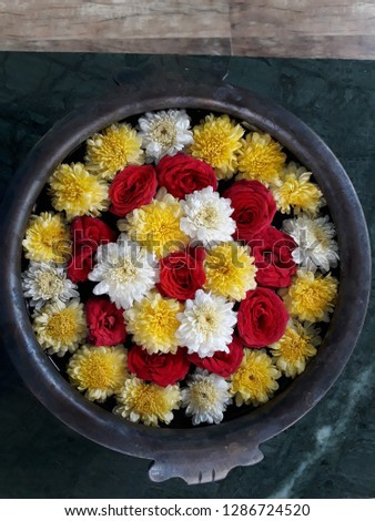 white and yellow chamomillas and roses arranged in bronze bowl closeup