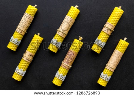 Buddhism. Candles with Yantras and mantras in sanskrit on black background top view pattern