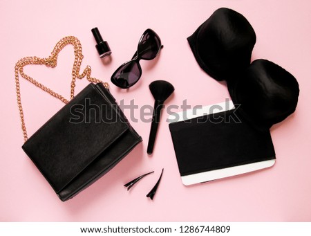 Fashionable female accessories on soft pink background. Clutch, sun glasses, nail polish, bra, makeup brush, spray, pins and other