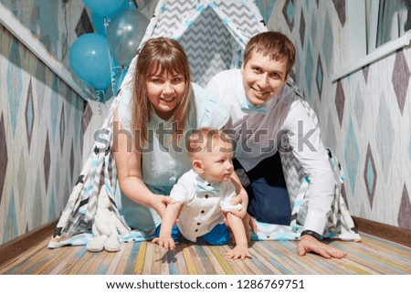 Couple with baby playing in the room. Mom, dad and son together. Photoshoot at home