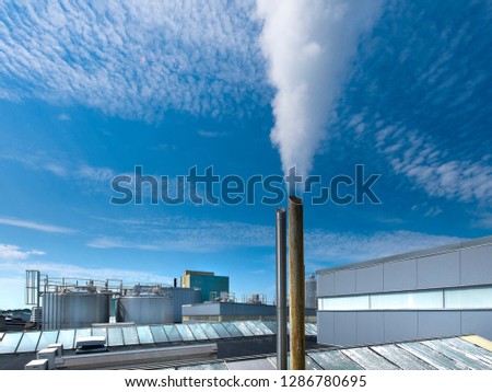 Industrial plant with a chimney on the roof to evacuate the high pressure hot steam. Royalty-Free Stock Photo #1286780695