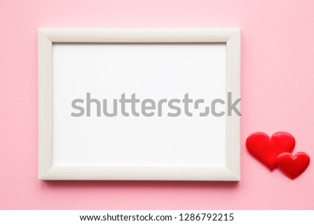 Blank photo frame for picture. Bright red textile hearts on pastel pink background. Mockup for positive idea. Free space. Empty place for lovely, emotional, sentimental text, quote or sayings. 