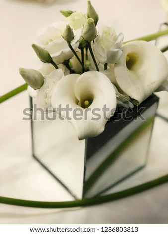 white calla and eustoma flowers in glass square vase