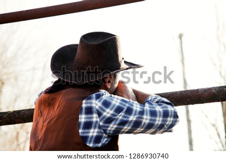 the quiet cowboy on a sunset evening with his cowboy hat at his farm