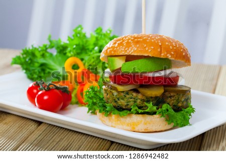 Tasty vegetarian hamburger with soybean cutlet, tomato, avocado and lettuce