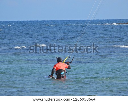 Extreme zoom photo of kitesurfer as seen in deep blue sea