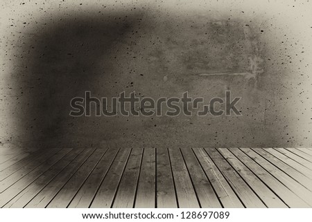 Wooden floorboards and concrete wall.