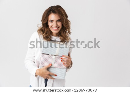 Image of happy woman in casual clothes holding present boxes isolated over white background