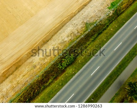 Graphic and abstract aerial view of the vertical photograph of a road with markings between fields, Germany