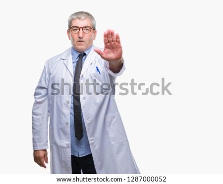 Handsome senior doctor, scientist professional man wearing white coat over isolated background doing stop sing with palm of the hand. Warning expression with negative and serious gesture on the face.
