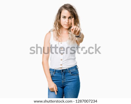 Beautiful young blonde woman over isolated background Pointing with finger up and angry expression
