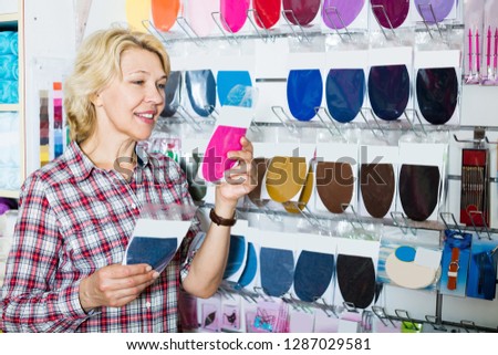 Happy customer woman buying textile patch in sewing departament in shop