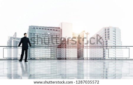 Young businessman in suit at balcony against morning cityscape background