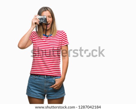 Young beautiful woman taking pictures using vintage photo camera over isolated background afraid and shocked with surprise expression, fear and excited face.